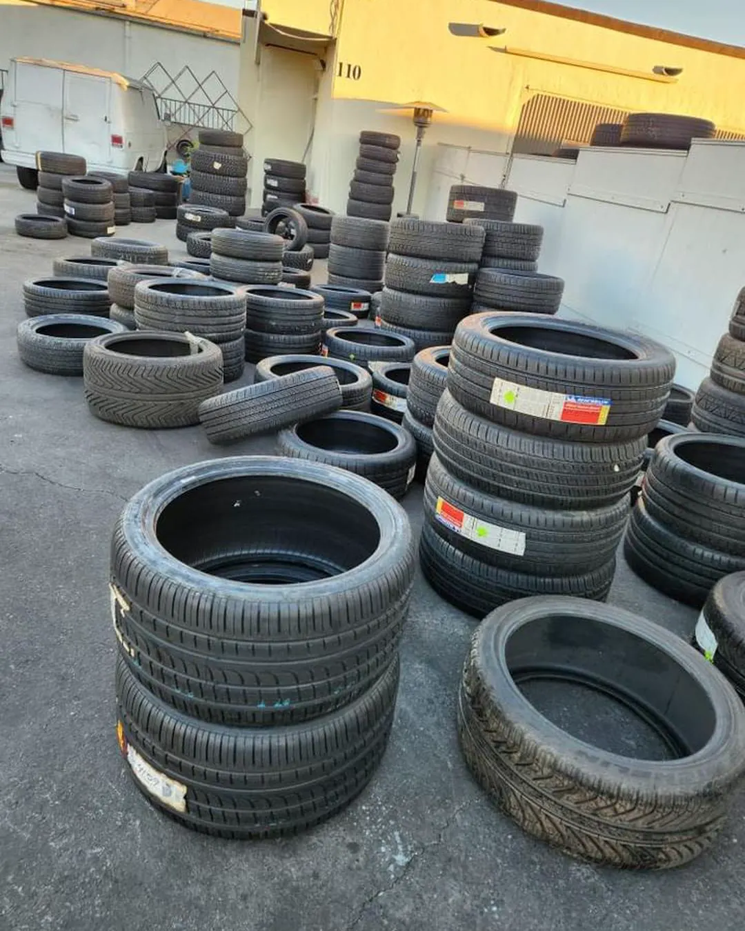 Tall tower of stacked tires with sizes written on the sidewalls